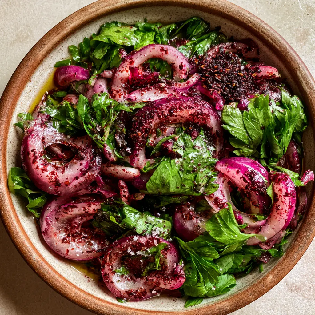 Turkish Onion Salad Recipe: Authentic Sumac Onions (Sumaklı Soğan) 1 A close-up of glistening Turkish onion salad with olive oil, lemon juice droplets, and flaky sea salt.
