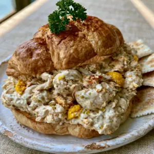 Smartphone food photography of the velvety Chicken Salad Chick Olivia's Old South with yellow egg bits and green relish. (Chicken Salad Chick Olivia's Old South)