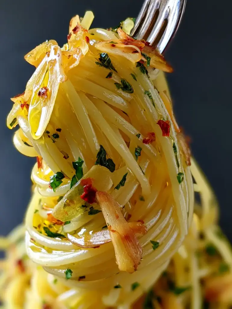 Close-up of golden extra virgin olive oil coating al dente spaghetti strands with vibrant red chili flakes.